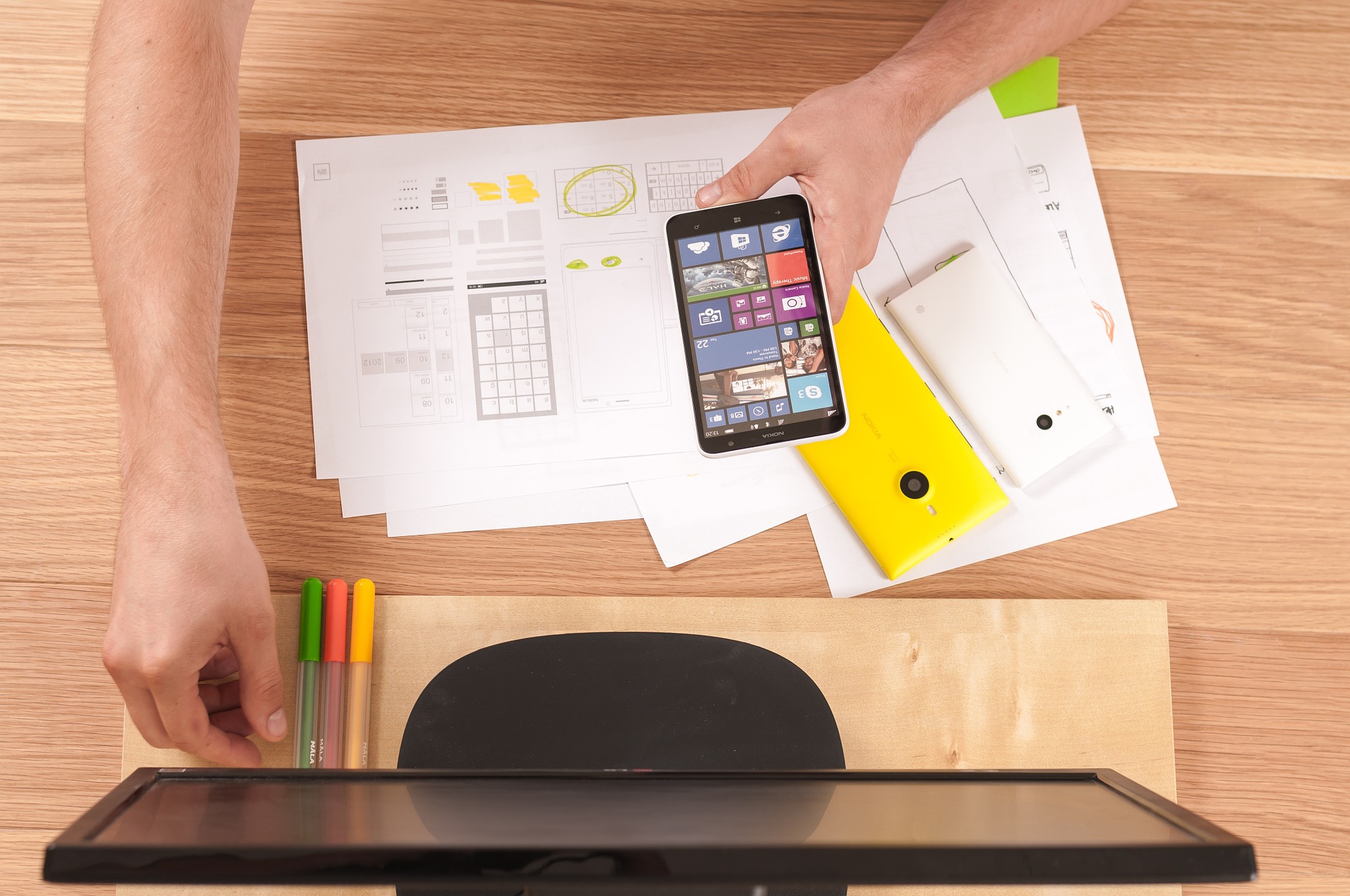 Ein Schreibtisch mit Computer und Smartphone Ein Schreibtisch mit Computer und Smartphone