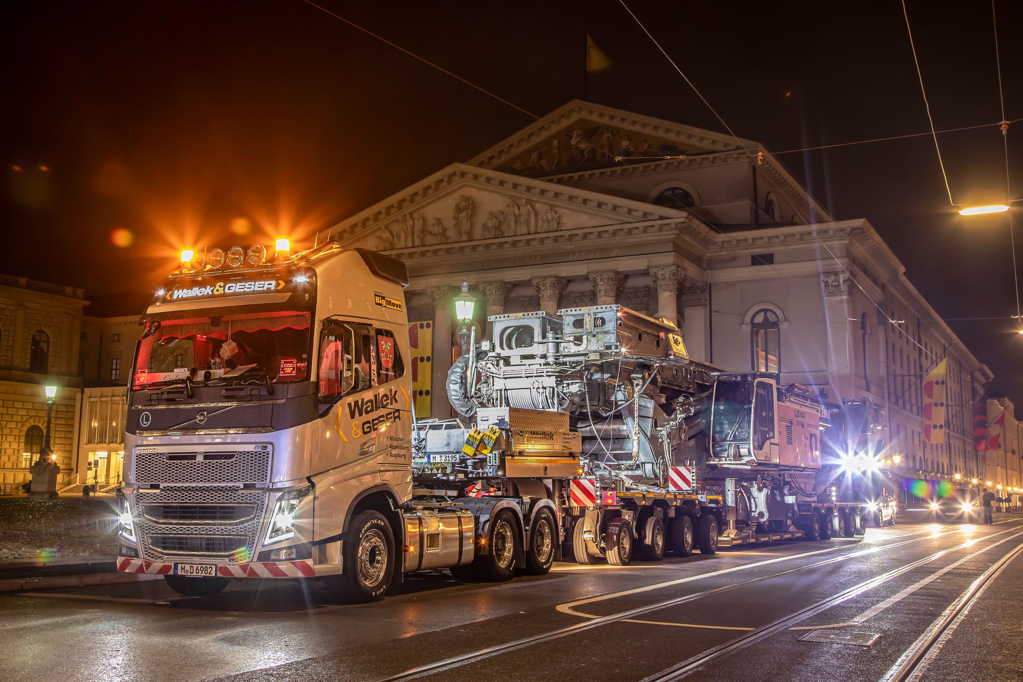 Ein Schwertransport fährt in der Nacht an einem großen, historischen Gebäude vorbei Ein Schwertransport fährt in der Nacht an einem großen, historischen Gebäude vorbei