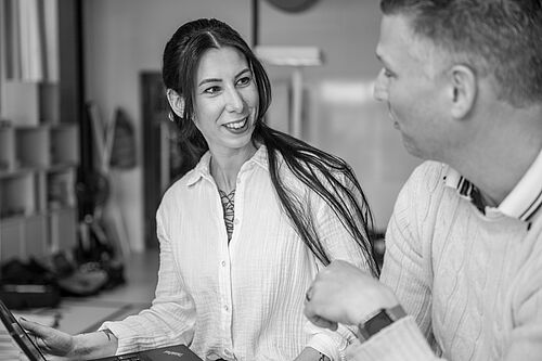 Ein Mann und eine Frau sitzen im Workshopraum der HEC und sprechen fröhlich miteinander.