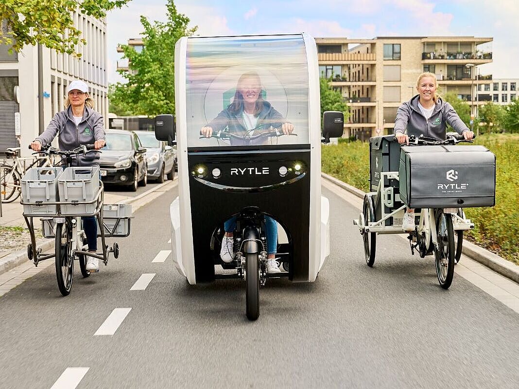 RYTLE E-Cargo-Bikes Drei verschiedene RYTLE E-Cargo-Bikes fahren auf einer Straße