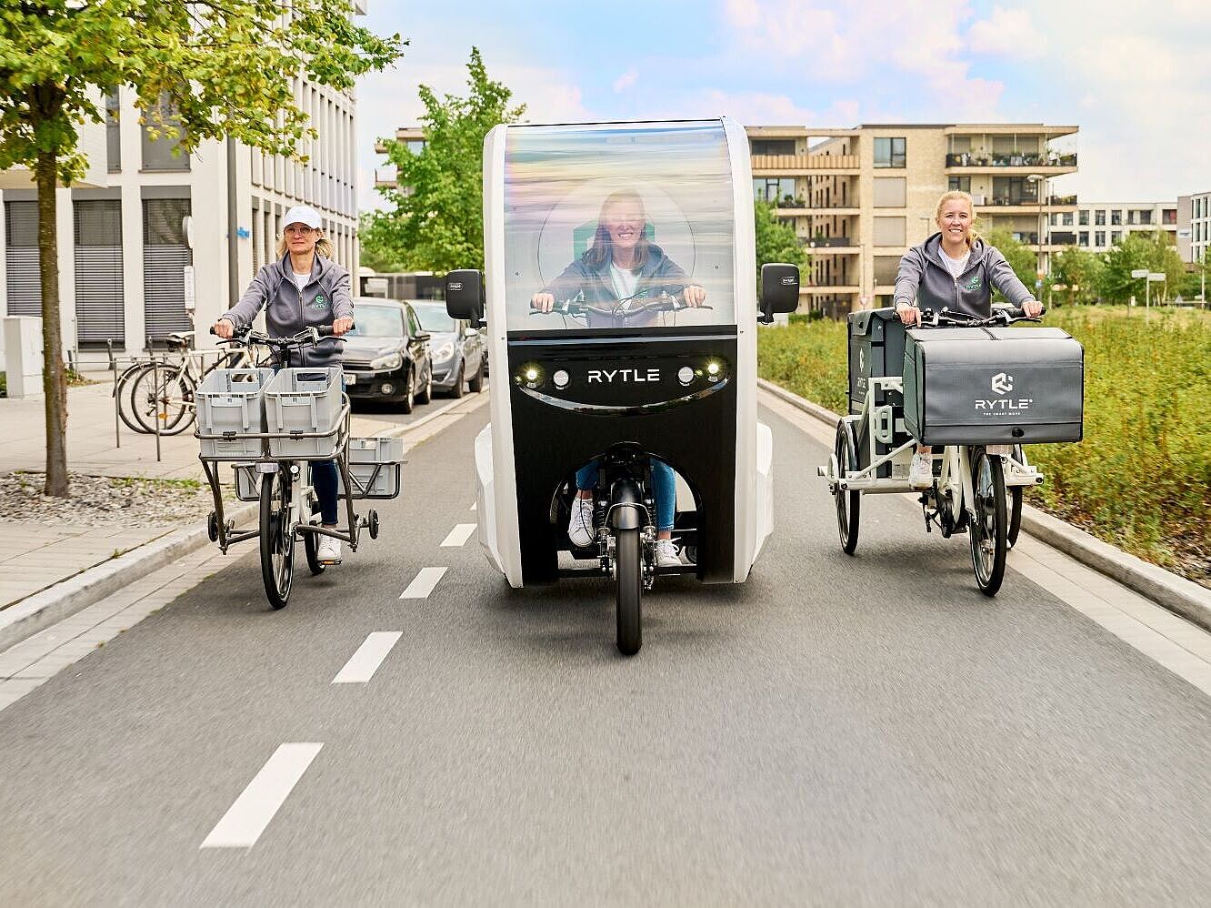 RYTLE E-Cargo-Bikes Drei verschiedene RYTLE E-Cargo-Bikes fahren auf einer Straße