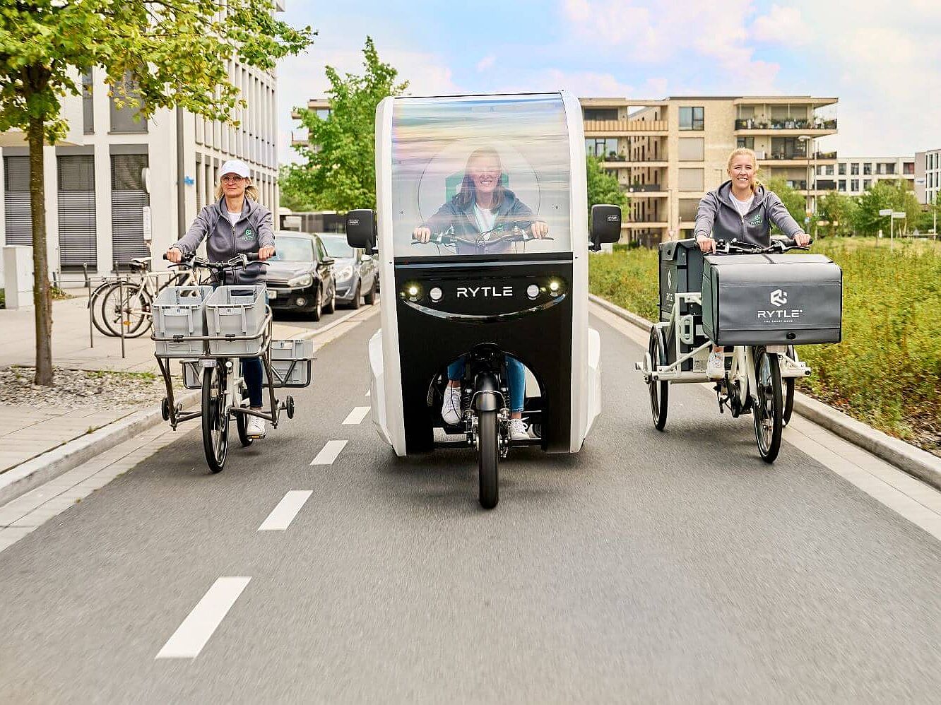 RYTLE E-Cargo-Bikes Drei verschiedene RYTLE E-Cargo-Bikes fahren auf einer Straße