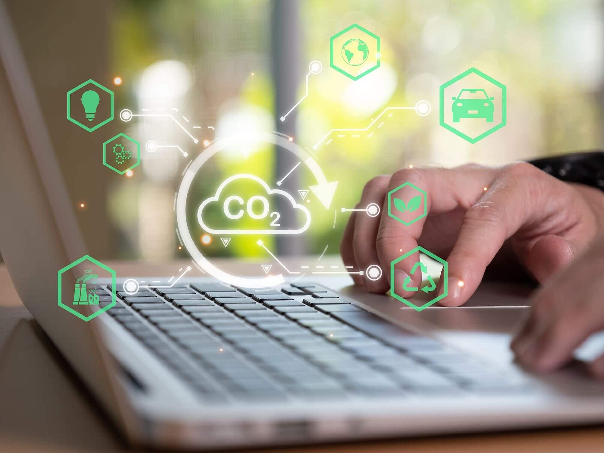 Hände auf Laptoptastatur mit visueller Wolke zum Thema Umweltschutz