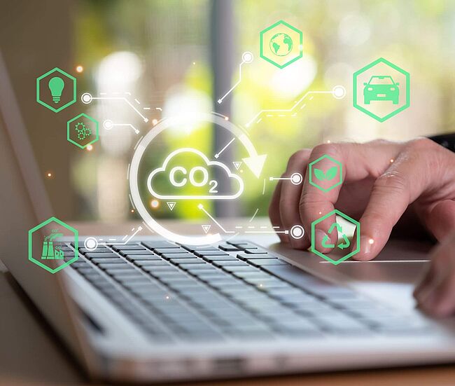 Hände auf Laptoptastatur mit visueller Wolke zum Thema Umweltschutz