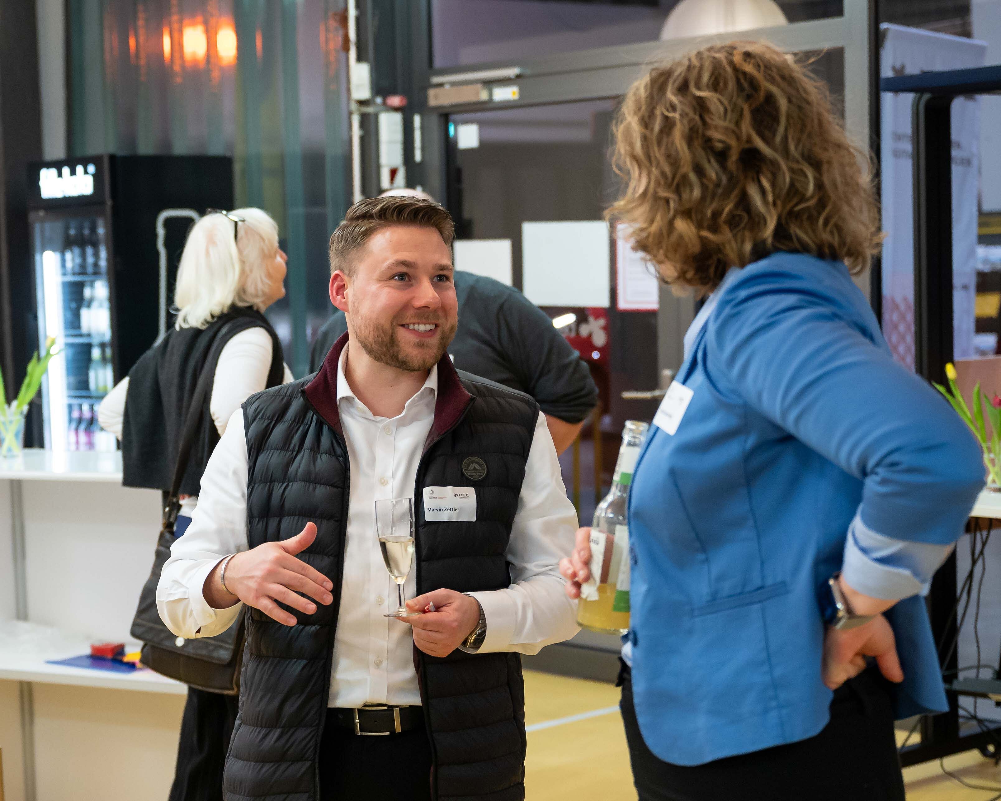 Ein Mann und eine Frau unterhalten sich bei der SOIREE|HEC.