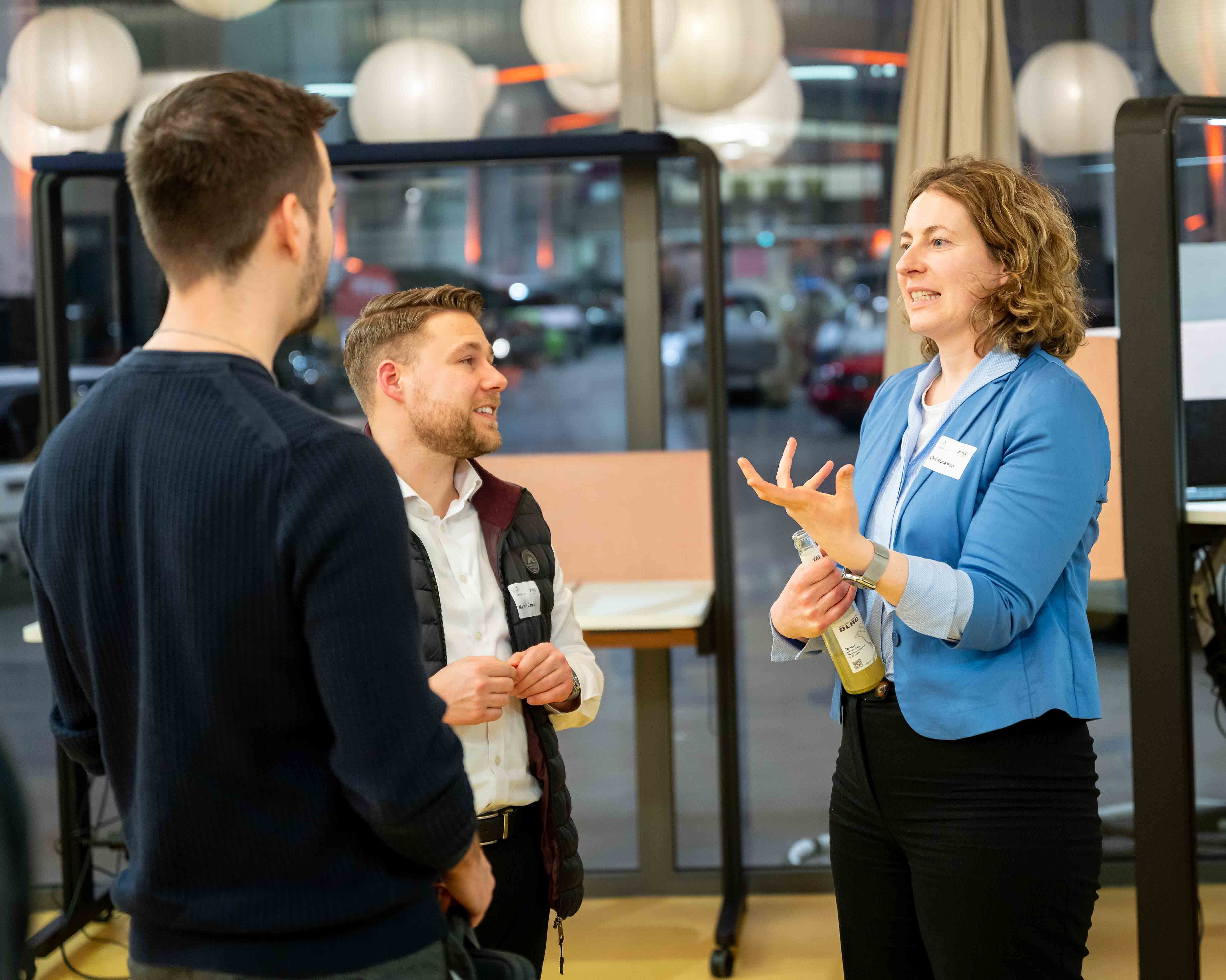 Zwei Männer und eine Frau unterhalten sich bei der SOIREE|HEC.