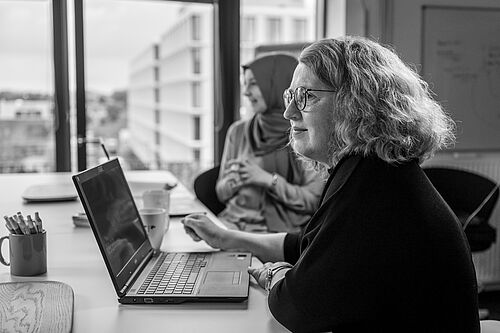 Teamarbeit im HEC Coworking-Bereich Eine Frau im Profil am Schreibtisch