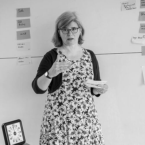 Eine Frau erläuternd vor einem Whiteboard