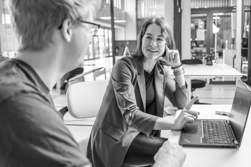 Eine Frau und ein Mann Besprechen sich vor einem Laptop