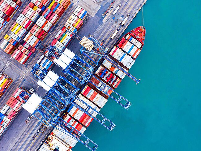 Container und Schiff am Terminal aus der Vogelperspektive