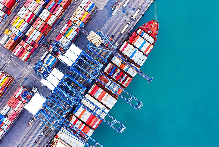 Container und Schiff am Terminal aus der Vogelperspektive