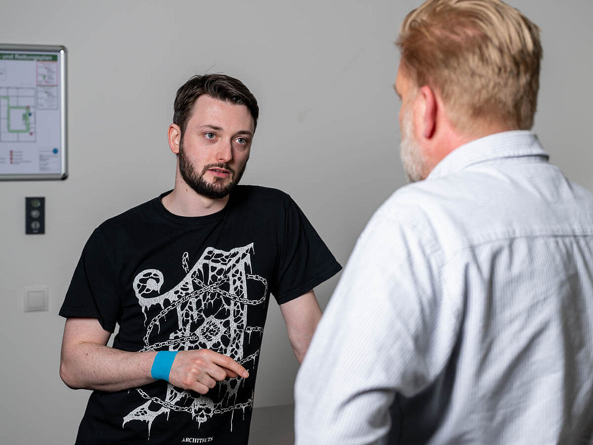 Kollegen besprechen ein Thema Zwei Männer stehend im Gespräch im Büro.