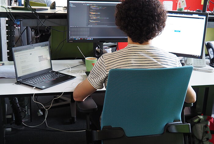 Ein Programmierer sitzt vor seinem Bildschirm