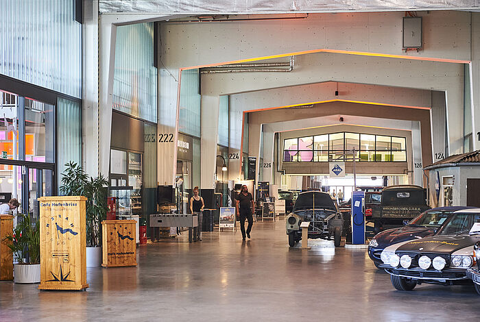 Blick durch die Länge des Atriums des Schuppen Eins, Historische Autos an der Promenade