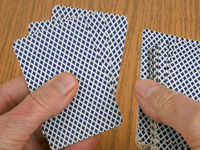 Zwei Hände halten Spielkarten gefächert