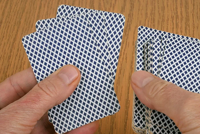 Zwei Hände halten Spielkarten gefächert