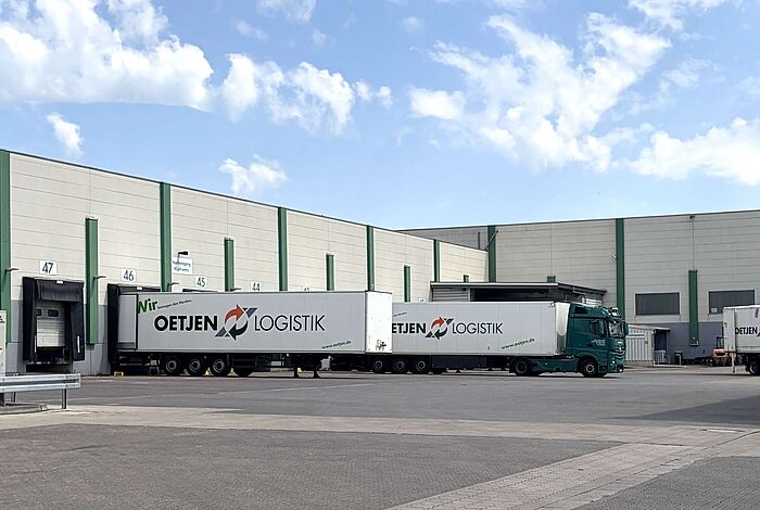 Im Hof einer Logistikfirma stehen zwei LKW.