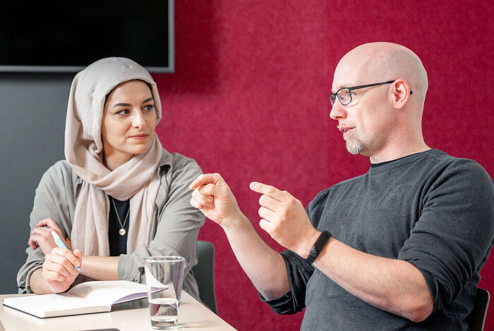 Eine Frau und ein Mann unterhalten sich angeregt.