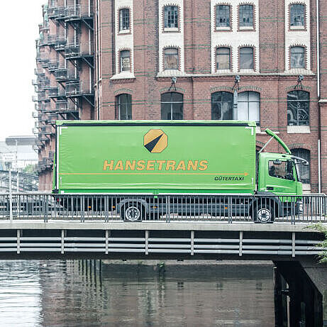 Hanstrans_Brücke Bild von zwei LKW's, welche eine Brücke überqueren.