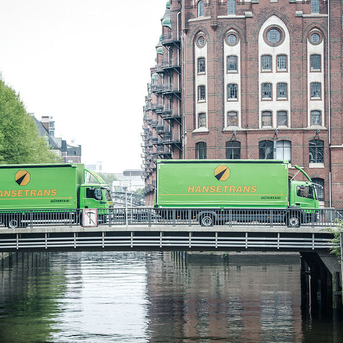 Bild von zwei LKW's, welche eine Brücke überqueren. 