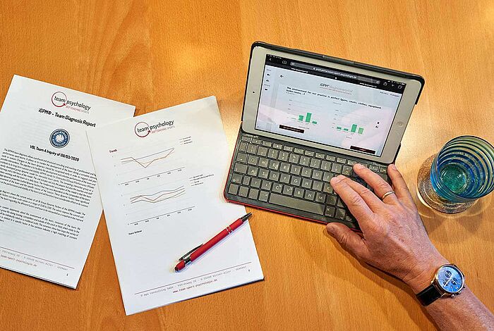 Blick auf einen Schreibtisch mit Laptop und Analysen