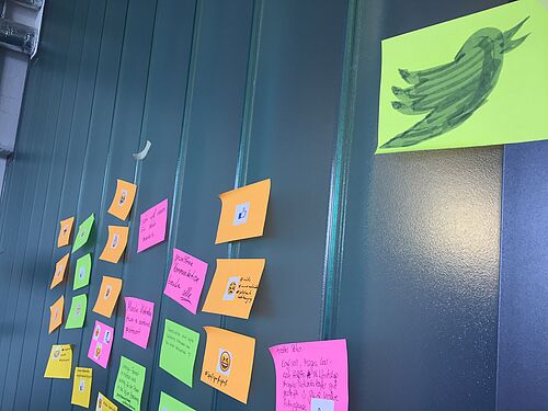 Post-its mit Twitter-Texten kleben an der Wand.