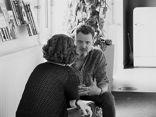 HEC Mitarbeiter Frank Düsterbeck sitzt im Gespräch in der Mediathek.