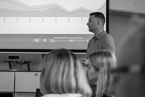 Referent der HEC im IT-Seminar vor Leinwand