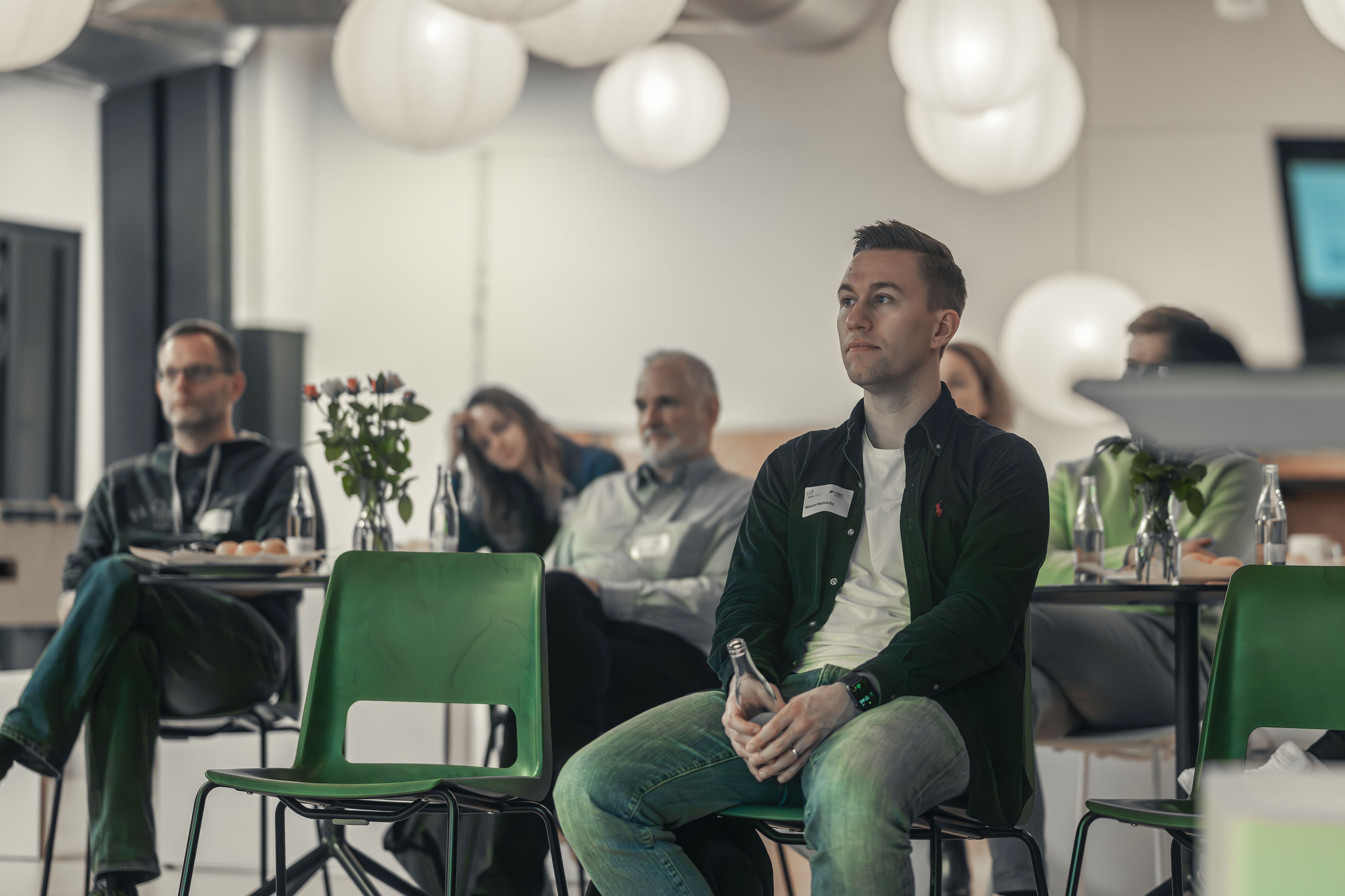 Personen hören einem Vortrag zu.