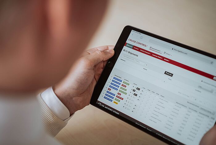 Ein Mann schaut auf ein Tablet mit einer Softwareanwendung.