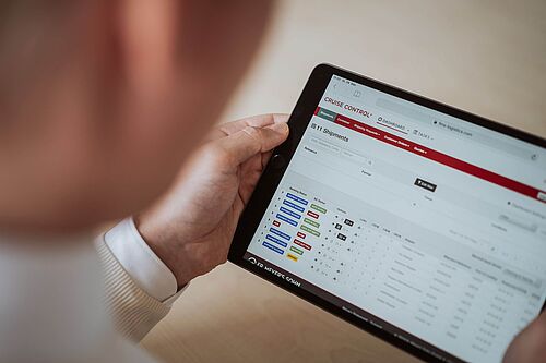 Ein Mann schaut auf ein Tablet mit einer Softwareanwendung.