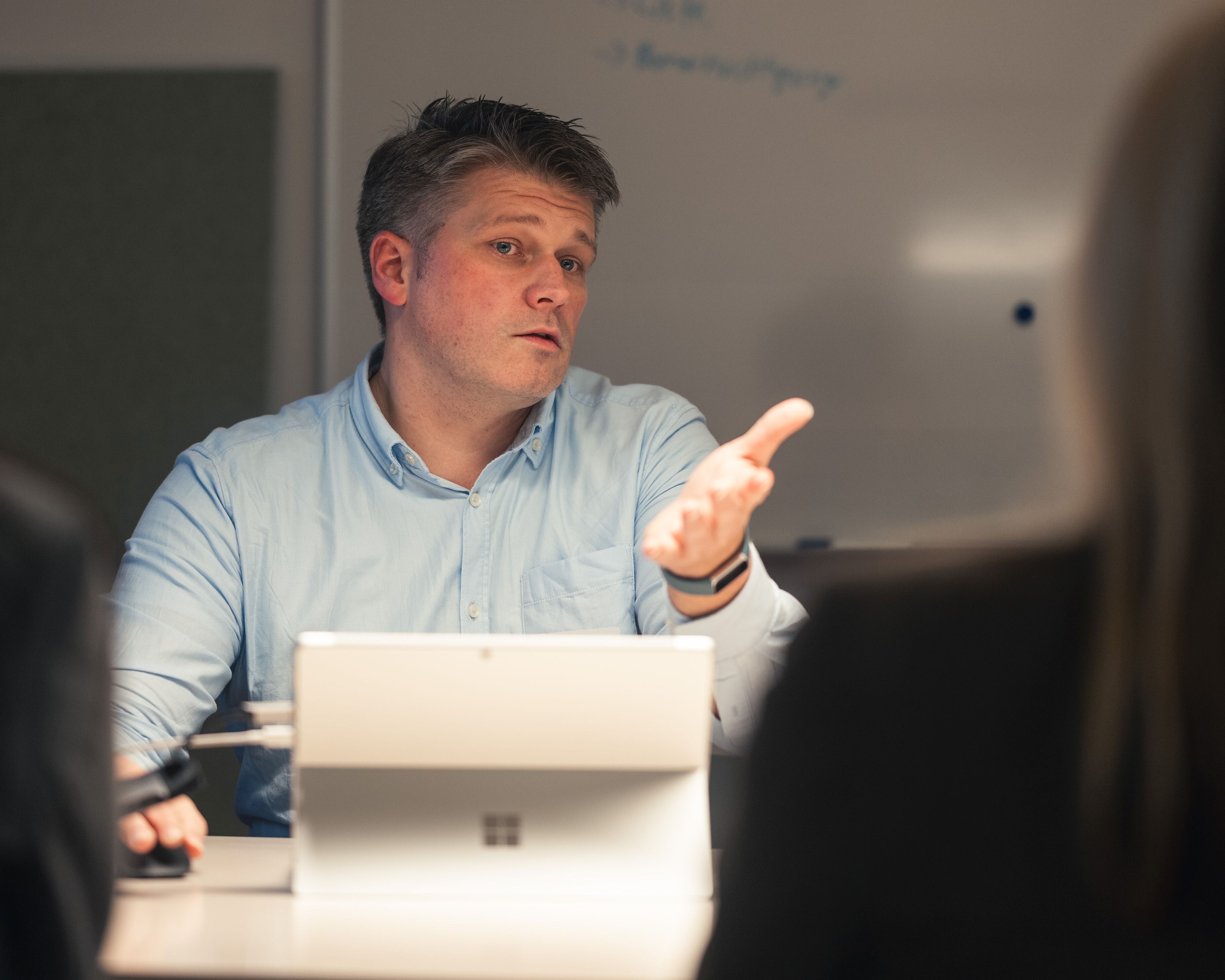 Ein Mann erklärt etwas an einem Laptop.