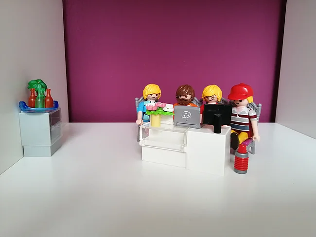 Playmobil-Figuren, die gemeinsam programmierende Entwickler:innen symbolisieren
