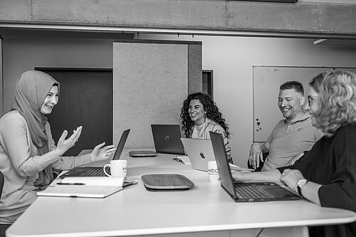 Gruppe um einen Schreibtisch herum