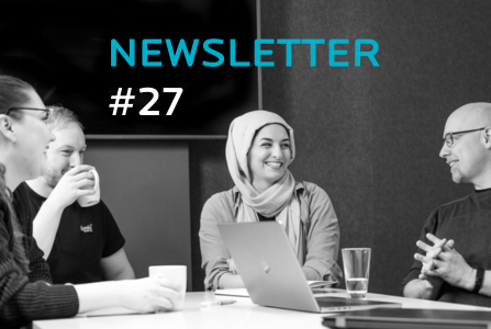 Vier Personen sitzen um einem Bürotisch und unterhalten sich.