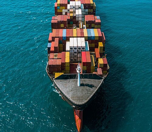Bild eines Frachters von oben, welcher Container transportiert. 