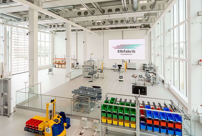 Blick in die Produktionshalle der Elbfabrik mit Regalen und Arbeitsstationen.
