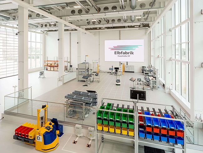 Blick in die Produktionshalle der Elbfabrik mit Regalen und Arbeitsstationen.