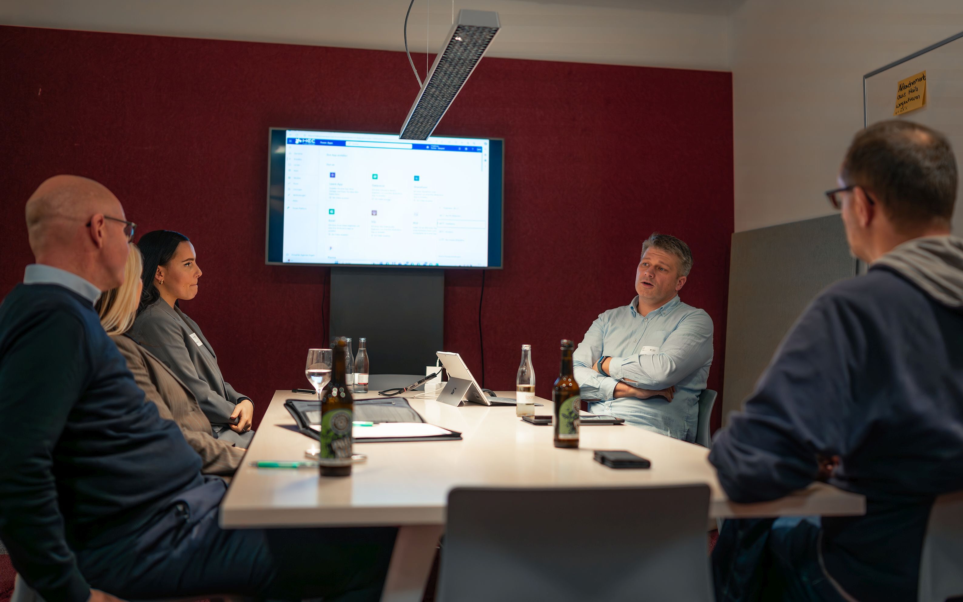 Vier Personen sitzen um einen Arbeitstisch.