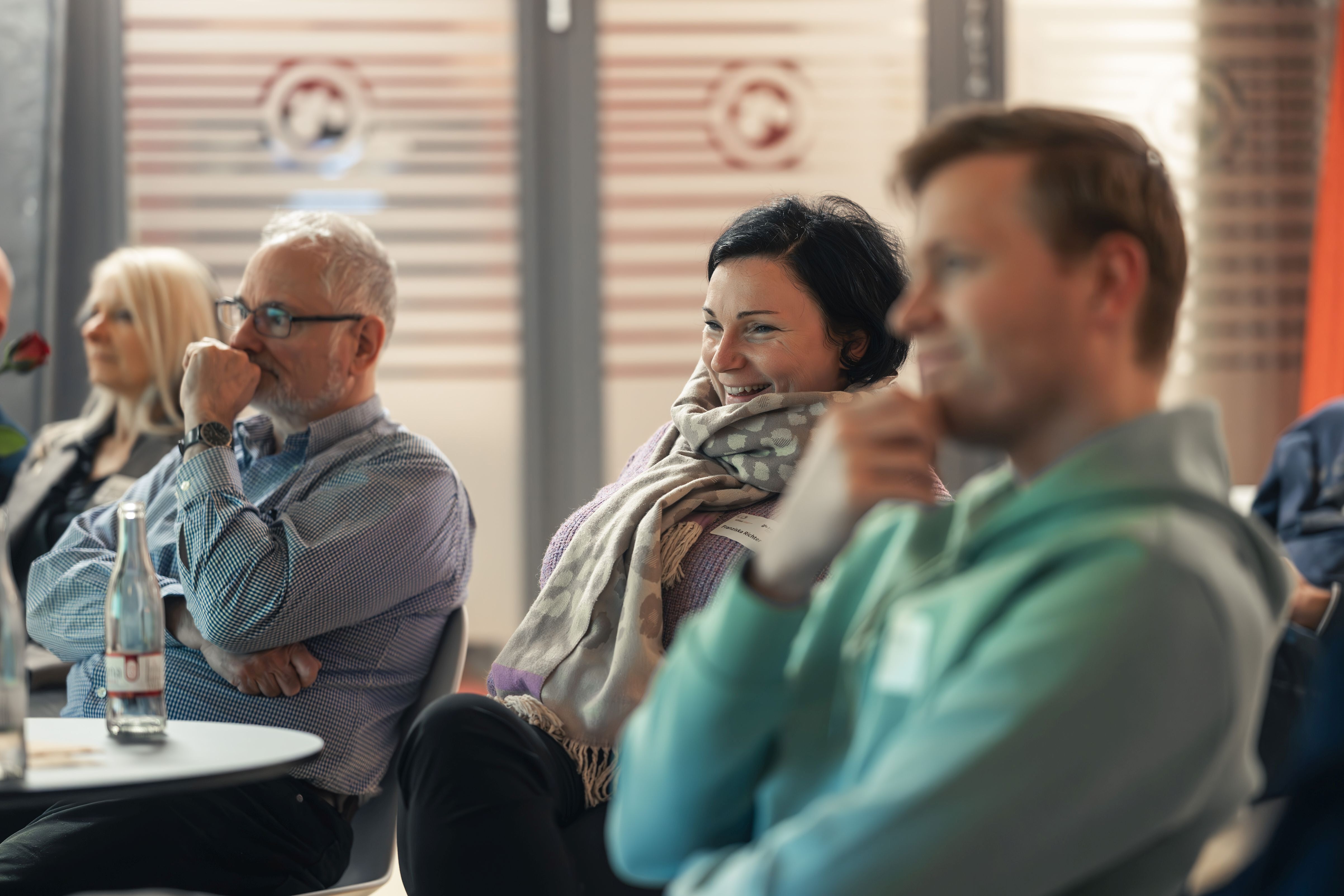 Personen hören einem Vortrag zu.