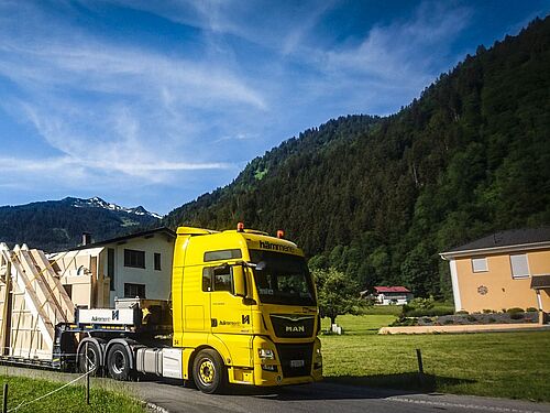Auf dem Bild ist ein großer LKW zu erkennen. Das Gehäuse des LKWs ist in einem knallige Gelbton gehalten. 