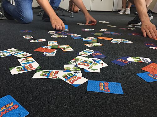Spielkarten sind auf dem Fußboden verteilt.