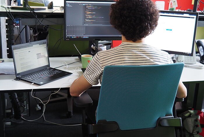 Ein Programmierer sitzt vor seinem Bildschirm