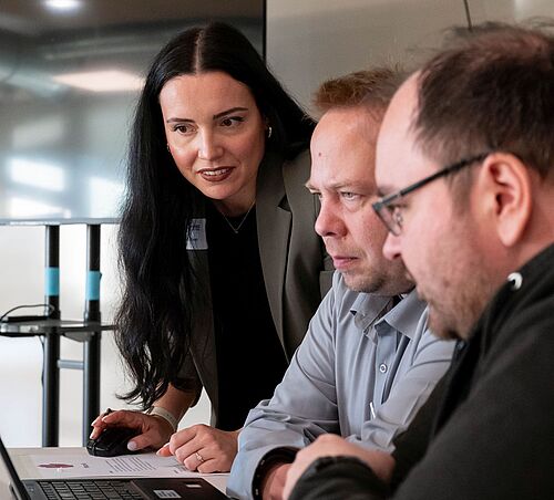 Charlene Walther erklärt Workshop-Teilnehmenden am Laptop, wie sich digitale Barrierefreiheit umsetzen lässt.