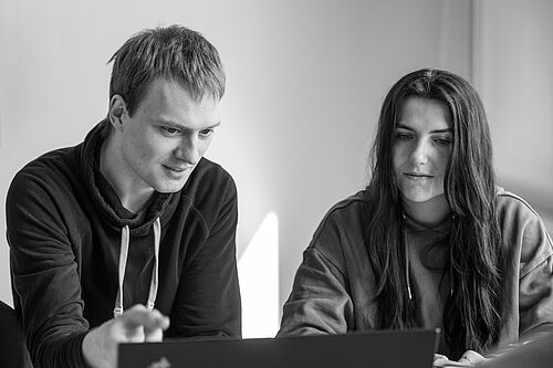 Zwei Personen besprechen etwas an einem Schreibtisch im Büro der HEC.