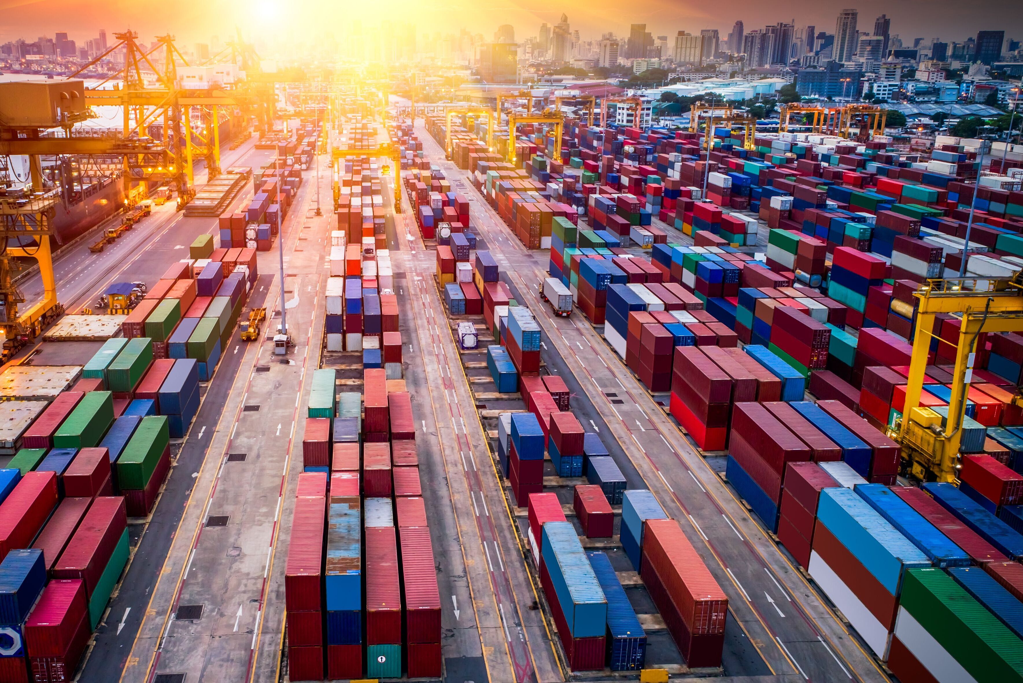 Containerterminal mit Sonnenuntergang im Hintergrund Containerterminal mit Sonnenuntergang im Hintergrund